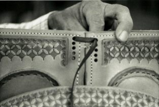 A Leddy's saddle maker hand threads the saddle skirt together.