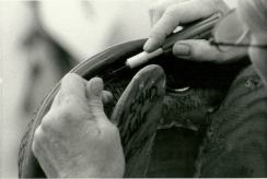 A saddle maker at Leddy's Saddle shop cuts a piece of trim to the perfect width.