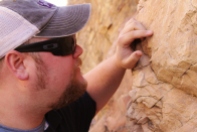 Texas Christian University student John Howard examines a section of rock exposed in a road cut along Interstate 80 outside of Salt Lake City Utah on October 23, 2013. (TCU/Bethany Peterson)